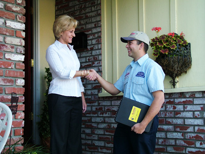 HVAC technician shaking hands with homeowner