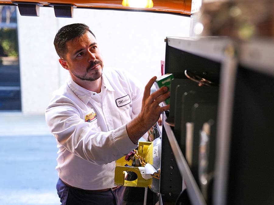 An Aladdin Air Conditioning & Heating technician in front of their service truck.